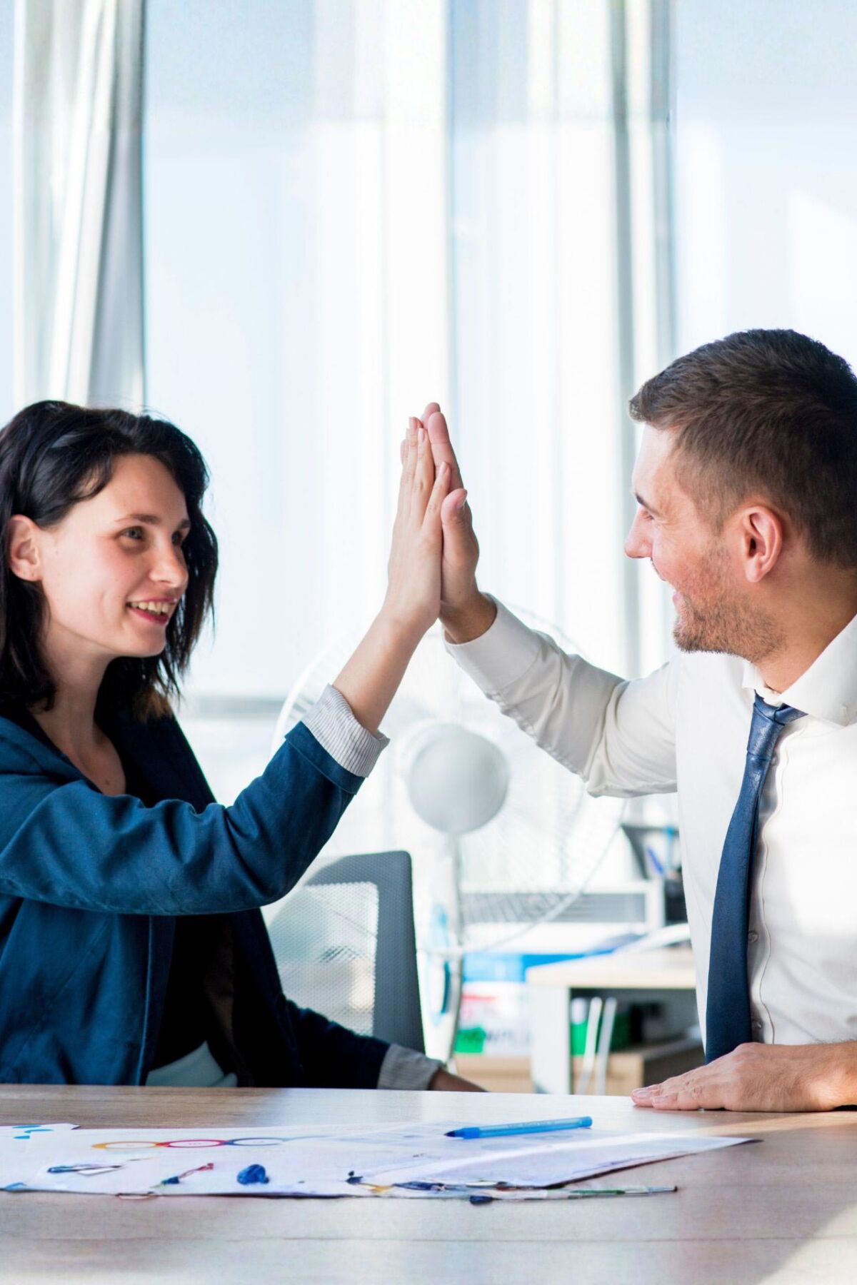 Ein Mann und eine Frau geben sich ein High Five.