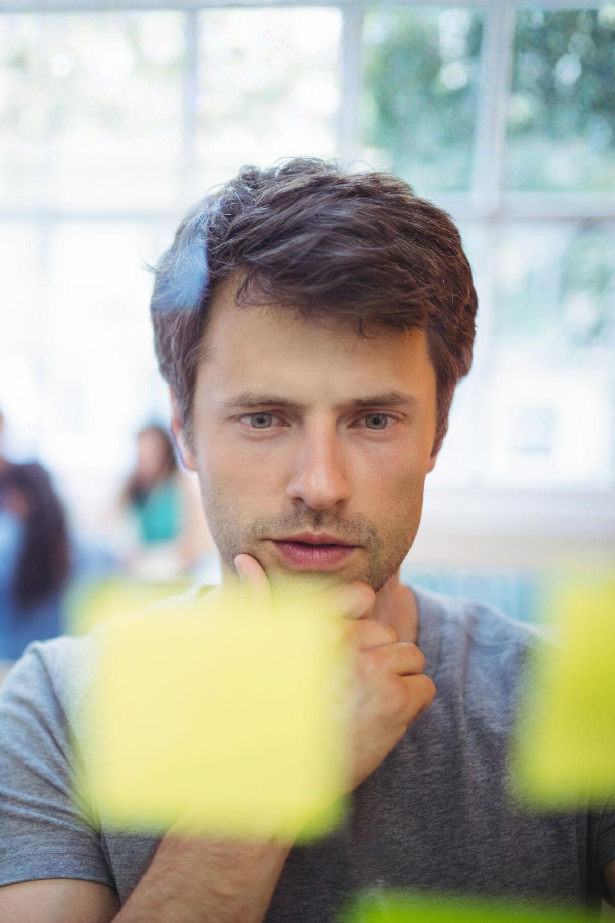 Ein Mann schaut nachdenklich auf Post-its.